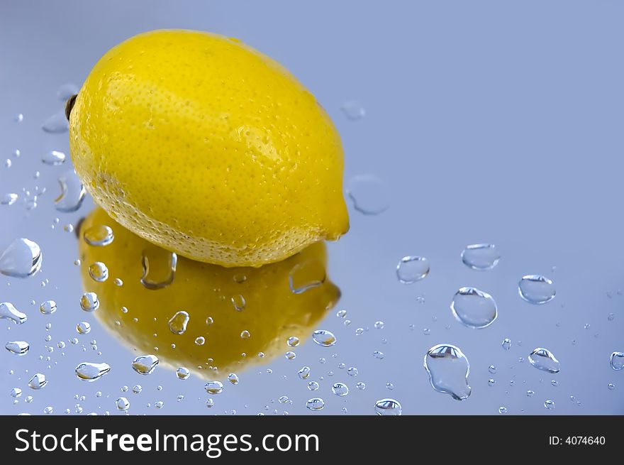 Single fresh lemon and water drops on reflecting surface. Single fresh lemon and water drops on reflecting surface