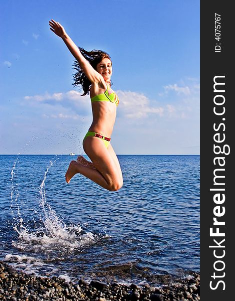 Pretty jumping woman on the sea background. Pretty jumping woman on the sea background