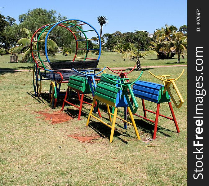 A childrenâ€™s ox wagon found in a park made out of metal pipes and painted bright colours. A childrenâ€™s ox wagon found in a park made out of metal pipes and painted bright colours