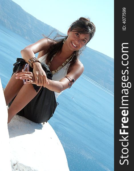 Cute girl above the roof in Oia Santorini Greece / Woman Pose. Cute girl above the roof in Oia Santorini Greece / Woman Pose