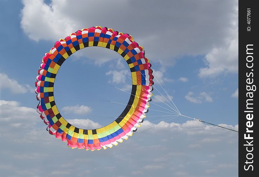 Very large, colourful, circular kite on a cloudy sky background. Very large, colourful, circular kite on a cloudy sky background.