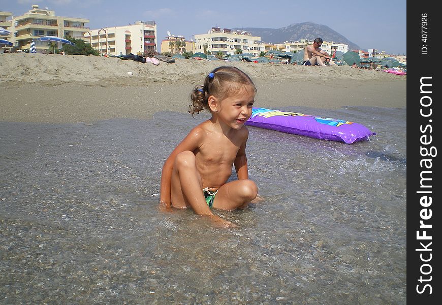 The happy girl on sea beach. Play in water. The happy girl on sea beach. Play in water.