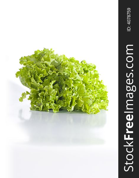 Isolated green lettuce reflecting on glossy white surface
