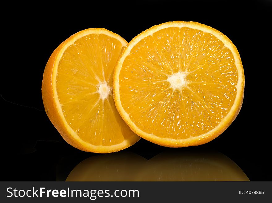 Citrus fruit  half oranges isolated over black mirror. Citrus fruit  half oranges isolated over black mirror