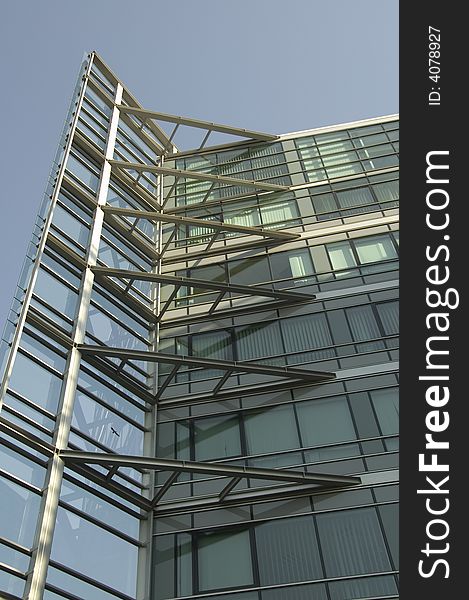 Modern office building detail from outside against blue sky.