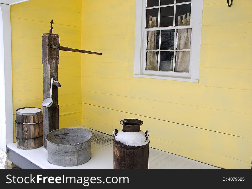 Typical homestead from 19th century farm and small town. Hand water pump and porch artifacts date the scene. Simple and tranquil scene. Typical homestead from 19th century farm and small town. Hand water pump and porch artifacts date the scene. Simple and tranquil scene.