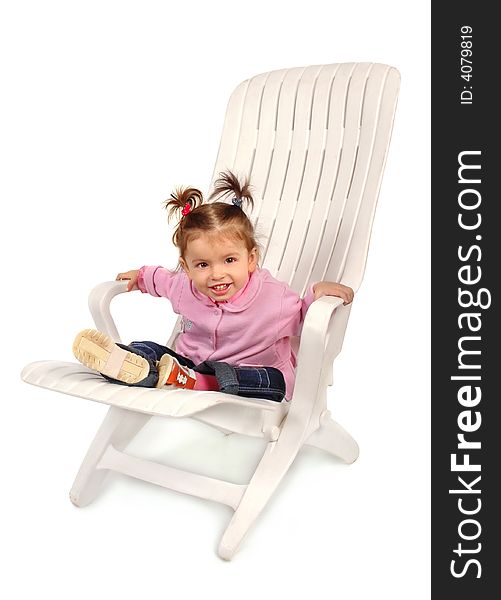 Small girl sitting on a chaise longue and smiling