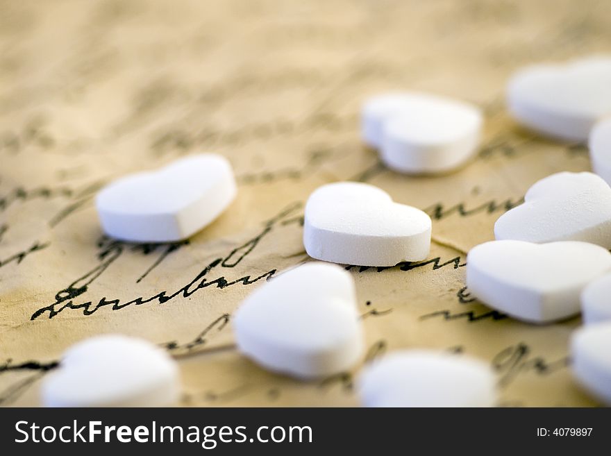 Little white peppermint hearts on handwritten letter. Little white peppermint hearts on handwritten letter