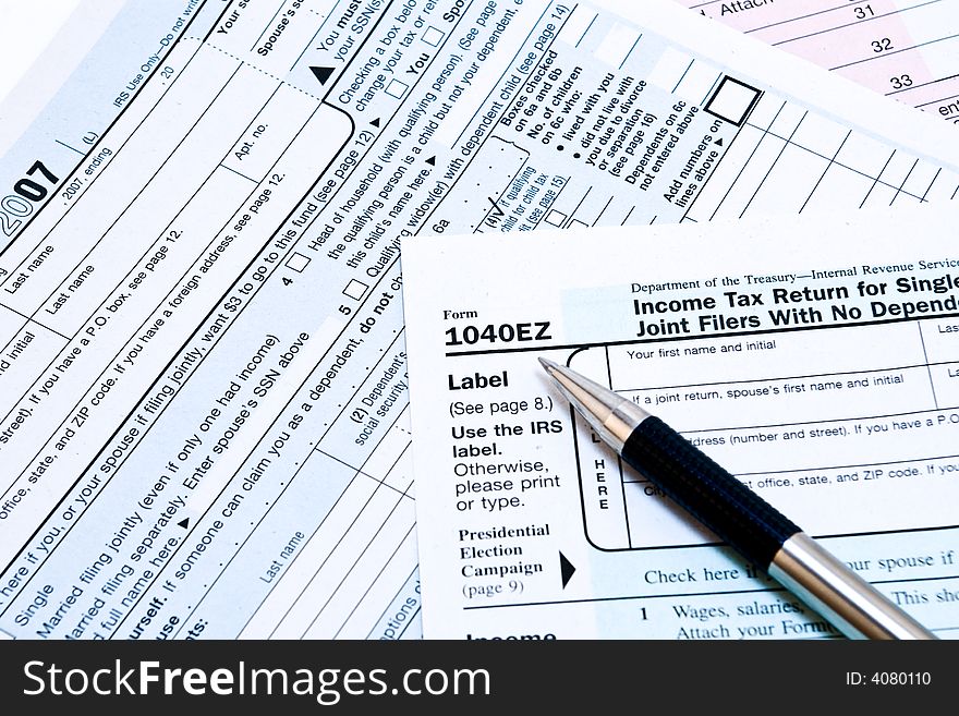 Image of 1040EZ IRS income tax forms with pen. Image of 1040EZ IRS income tax forms with pen