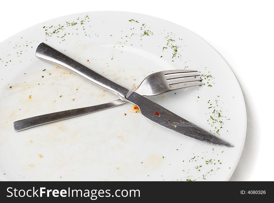 Unwashed fork and knife after eating lying on plate. Unwashed fork and knife after eating lying on plate