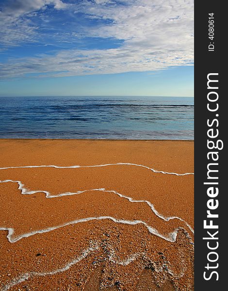 Orange sand beach and empty blue sea. Orange sand beach and empty blue sea.