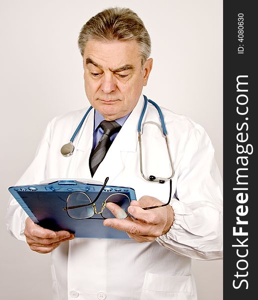 A mature male doctor looking at patient's chart.