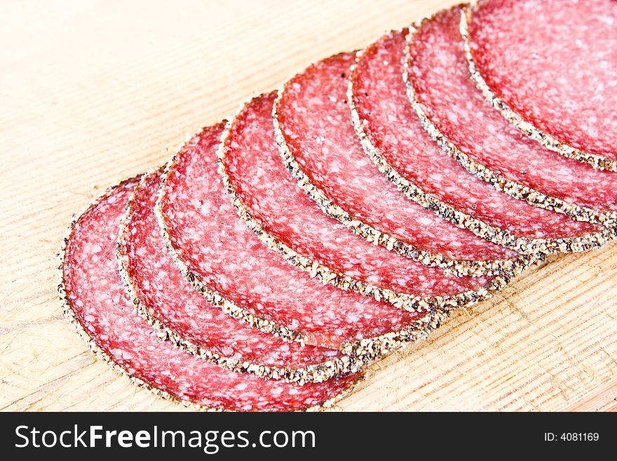 Peppered salami on a wooden chopping block