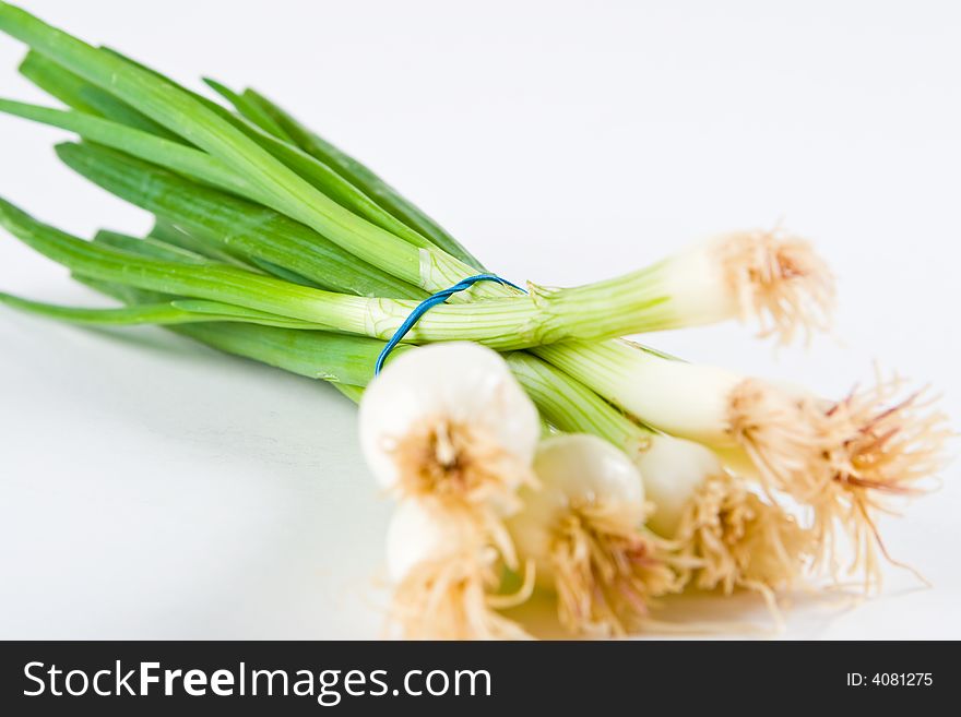 A bunch of spring onions on a white background