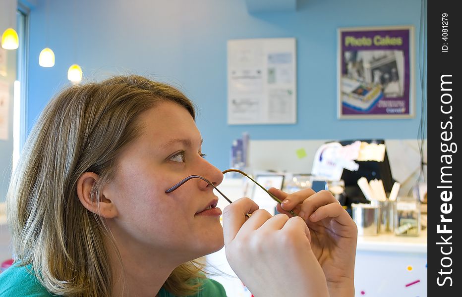 Picture of a woman taking off her glasses to take a closer look