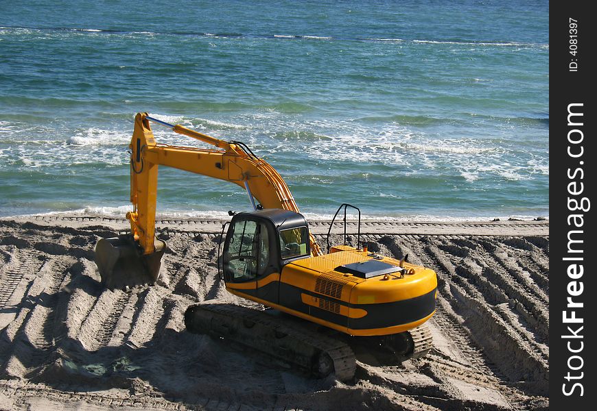 Excavator being used to construct sea defences on the beach. Excavator being used to construct sea defences on the beach