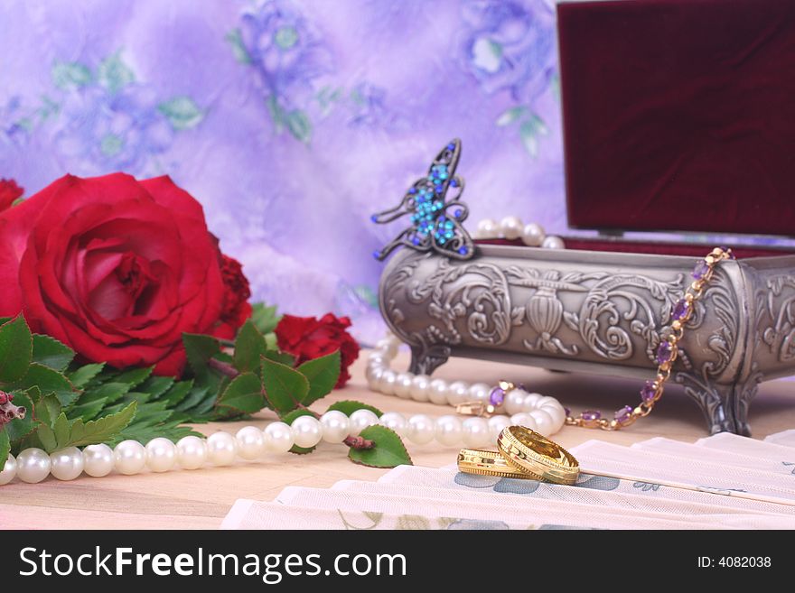 Roses With Pearls and Wedding Rings on Floral Background. Roses With Pearls and Wedding Rings on Floral Background