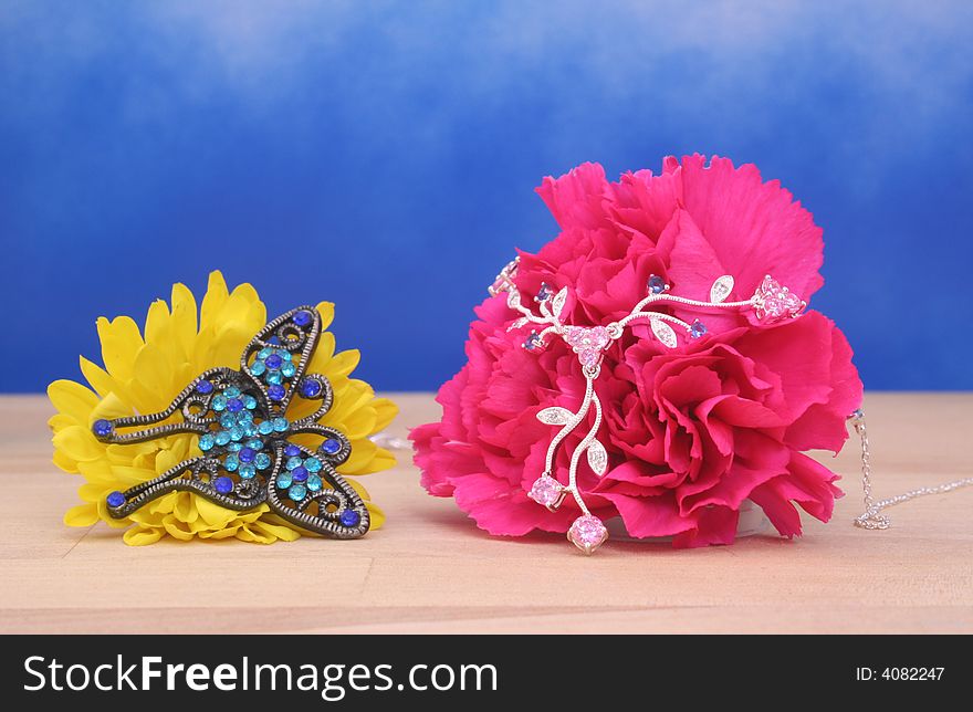 Jewelry and Flowers on Blue Background