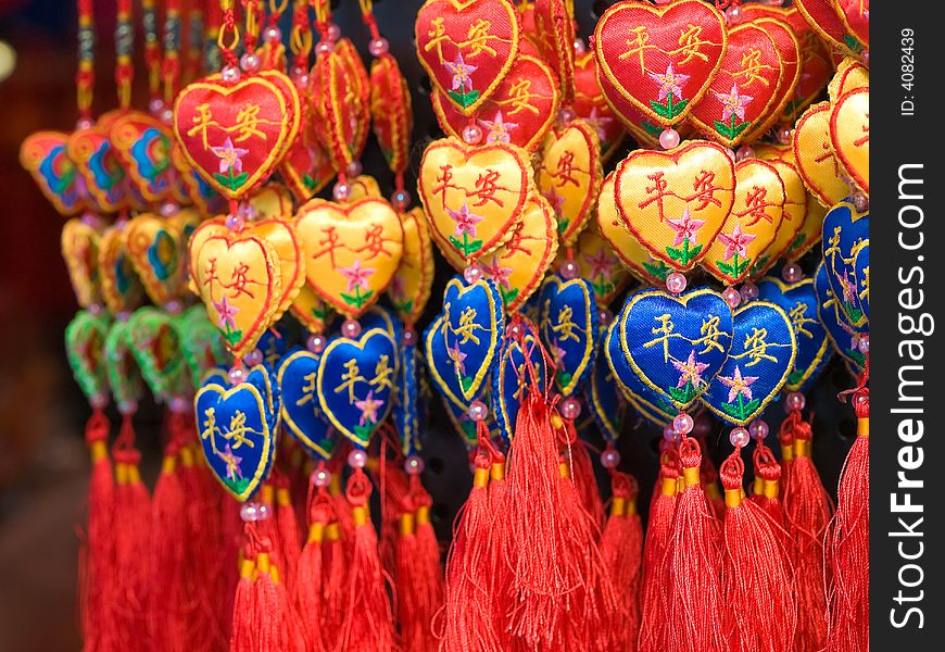 Hanging hearts ornaments in threes made of silk and embroidered with flowers and the Chinese characters, Ping An, meaning peace.