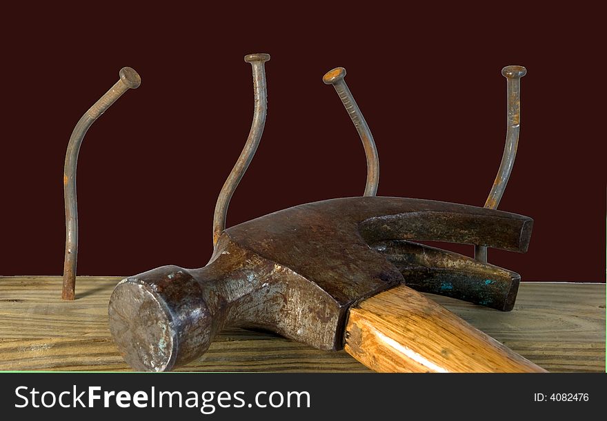 Claw hammer with four bent nails against red background. Claw hammer with four bent nails against red background