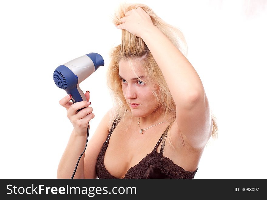 The young woman stacks hair by means of a hair drier. The young woman stacks hair by means of a hair drier