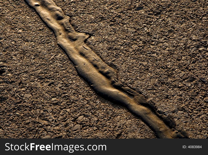 Diagonal line of tar on an asphalt road. Diagonal line of tar on an asphalt road