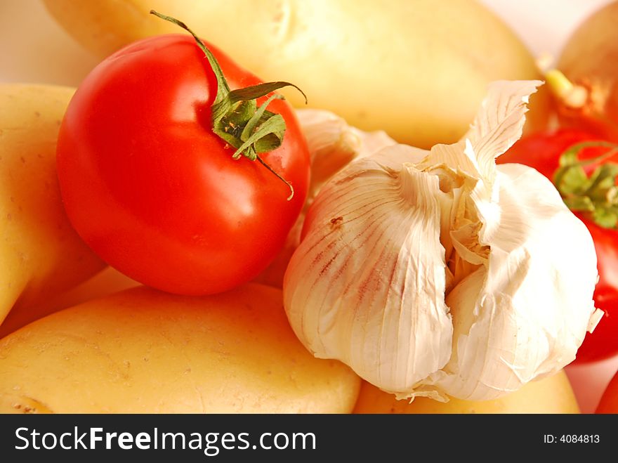 Close up of garlic, tomato, potatoes and onion. Close up of garlic, tomato, potatoes and onion