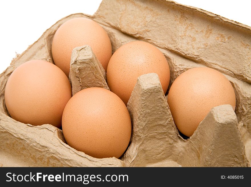 Five brown eggs in a carton. White background.