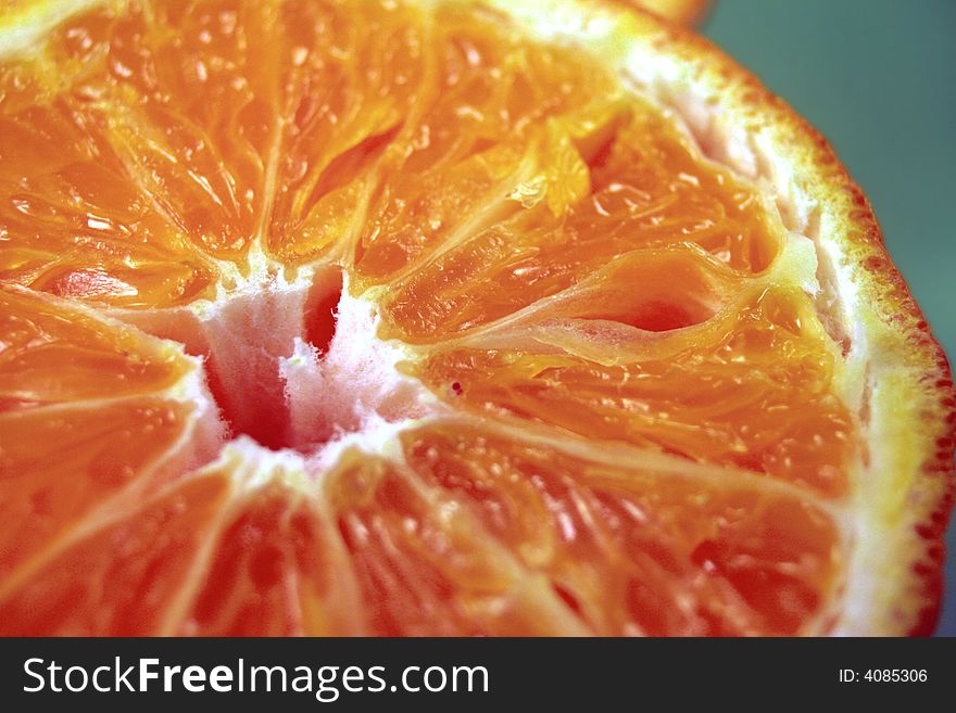Half orange fruit close up on green background