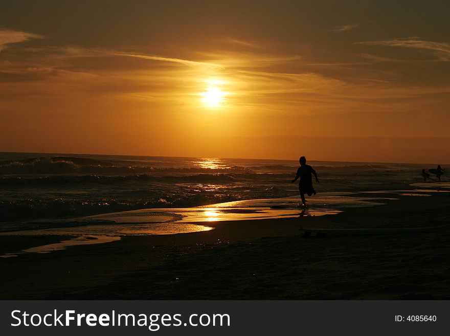 Boy jogging at sunset on beach in florida. Boy jogging at sunset on beach in florida
