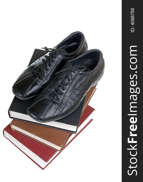 Man's shoes on books on a white background