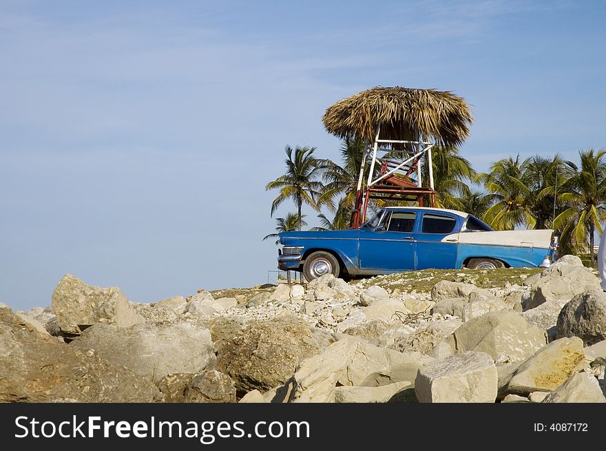 Oldtimer on rocky tropical beach background. Oldtimer on rocky tropical beach background