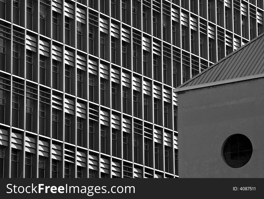 An abstract black and white image of a side of a building showing windows and shutters. An abstract black and white image of a side of a building showing windows and shutters