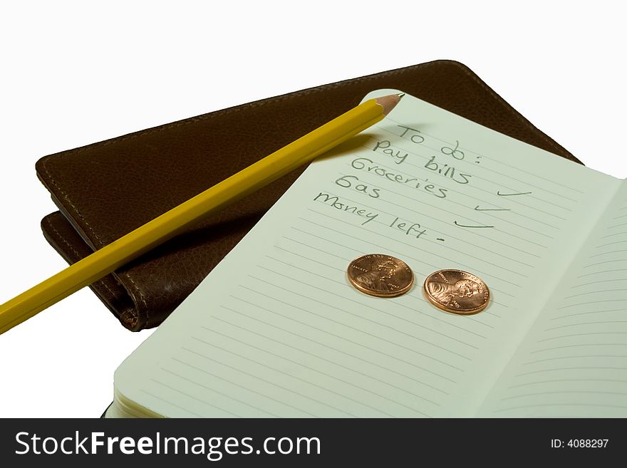 A brown leather checkbook resting on a white background with an open to do list, a pencil and two US pennies. A brown leather checkbook resting on a white background with an open to do list, a pencil and two US pennies.