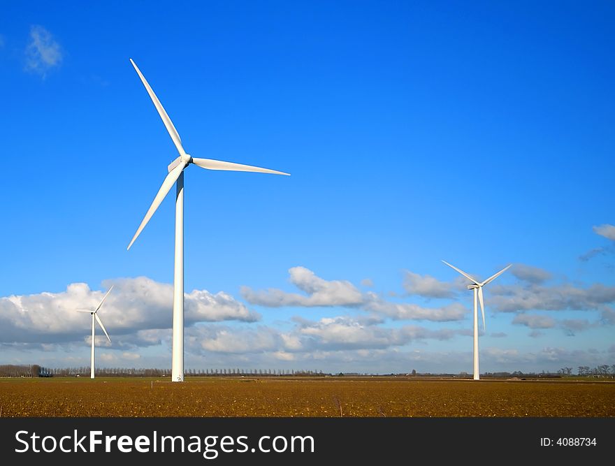 Wind Turbines in the field with blue cloudy sky