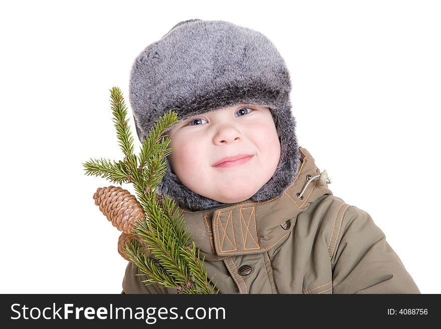 A smiling boy dressed for winter with a branch of fur tree with cones. A smiling boy dressed for winter with a branch of fur tree with cones