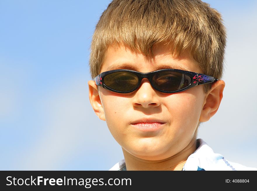 Boy with a smirk on his face and wearing sunglasses. Boy with a smirk on his face and wearing sunglasses