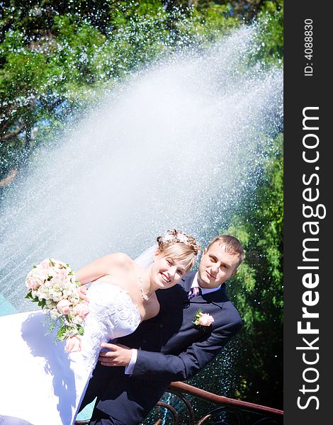 Happy bride and a groom near the fountain. Happy bride and a groom near the fountain