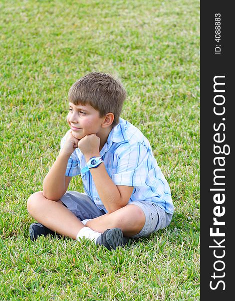 Boy sitting happily on the grass