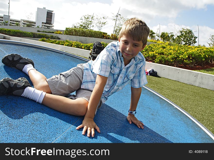 Boy spinning on a turn table in the park. Boy spinning on a turn table in the park