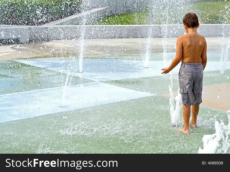 Boy playing in the water fountains. Boy playing in the water fountains