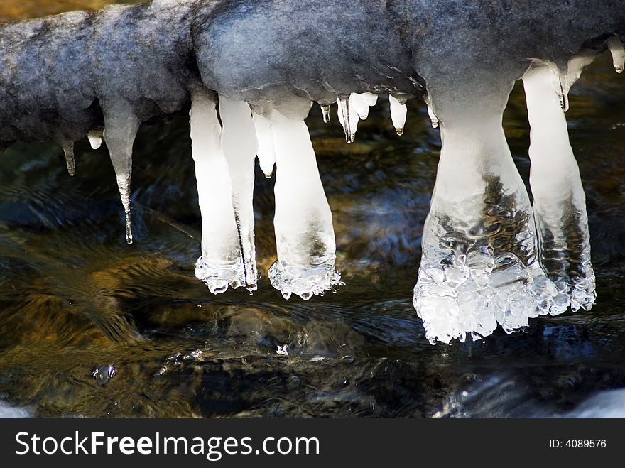 Artistic icicles hanging over a creek. Artistic icicles hanging over a creek.