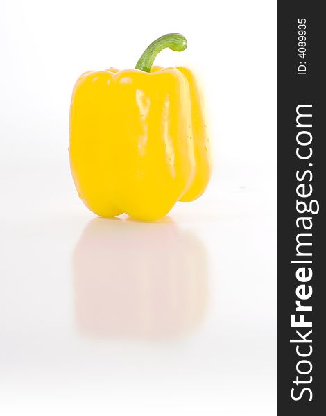 Sweet yellow pepper isolated on white with reflection on glossy surface.