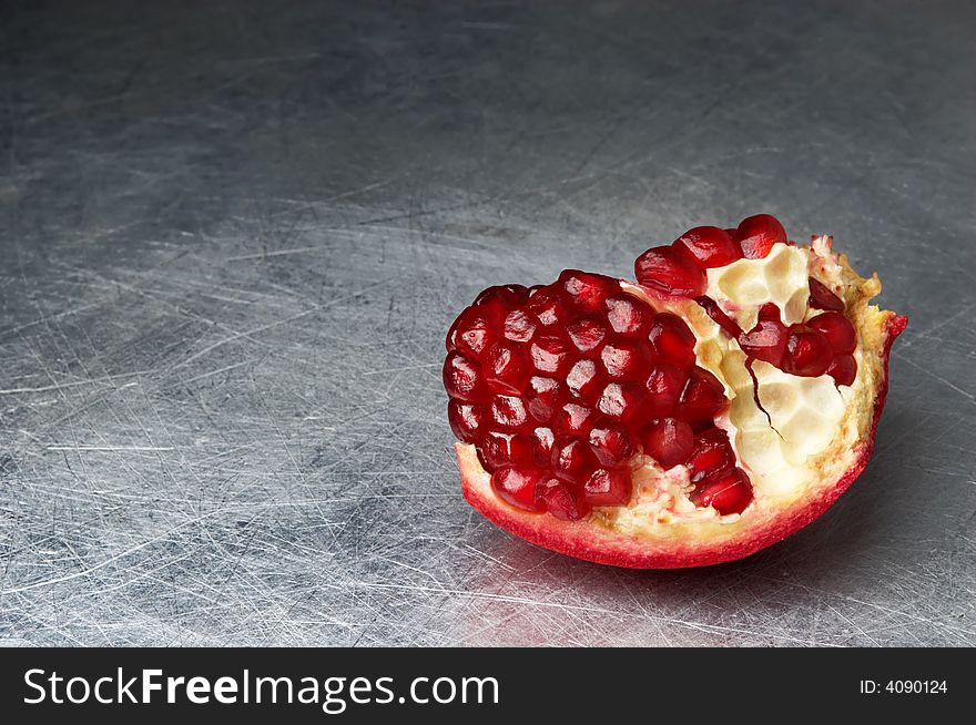 Broken pomegranate on scratched metall