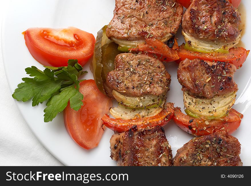 Kebab served with vegetables on white plate, closeup. Kebab served with vegetables on white plate, closeup