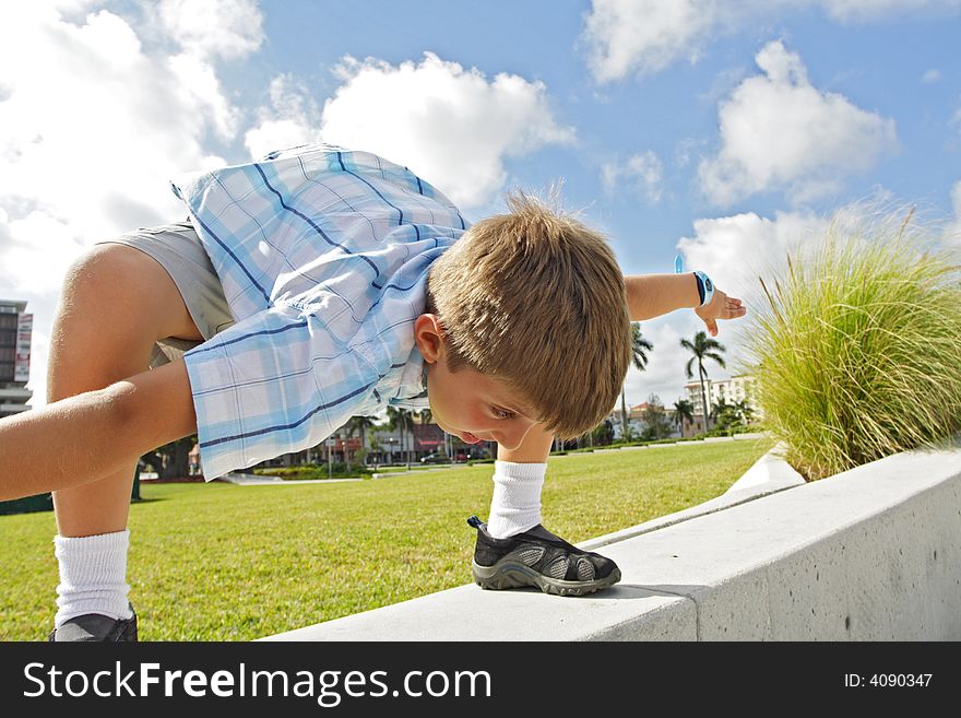 Boy crouching over on a ledge. Boy crouching over on a ledge