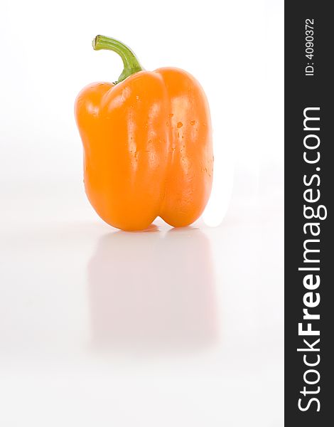 Sweet orange pepper isolated on white with reflection on glossy surface.