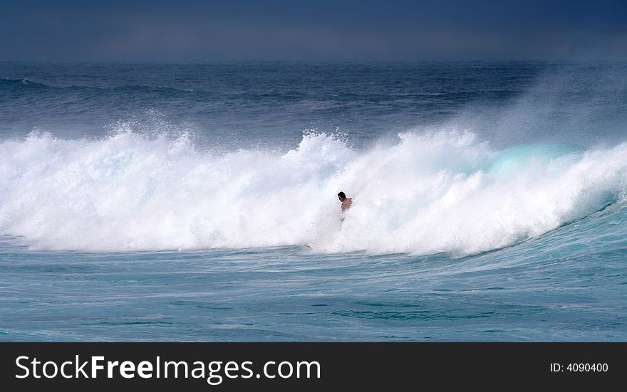 A young surfer is barely visible in choppy white waves on a beach in Maui, Hawaii. A young surfer is barely visible in choppy white waves on a beach in Maui, Hawaii