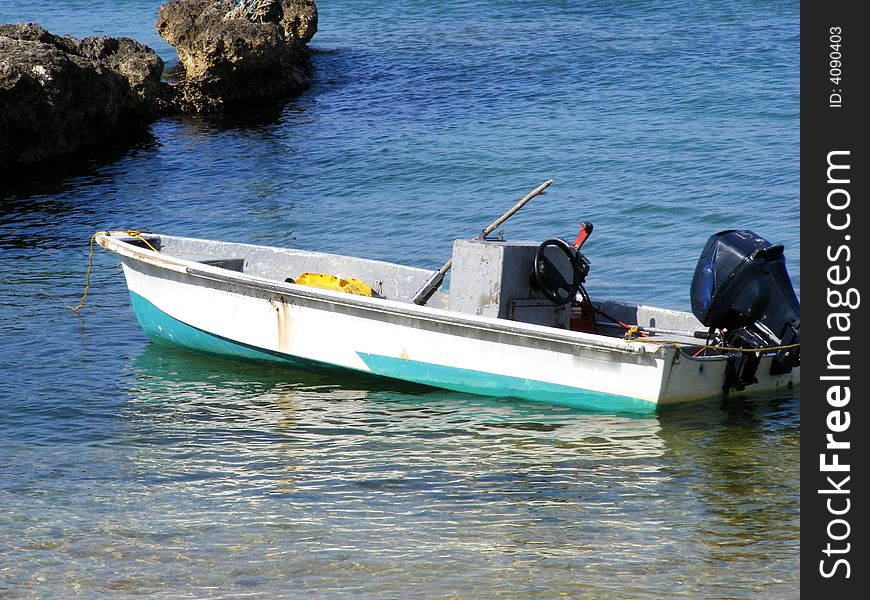 A single boat in the waters of the Caribbean off an island. A single boat in the waters of the Caribbean off an island.