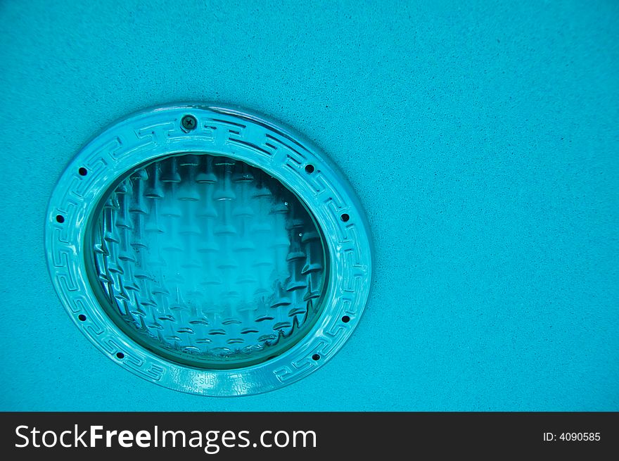 Horizontal view of underwater pool light in clear blue water